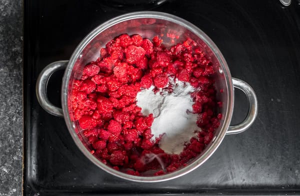 a pot of raspberries with powdered pectin on a stove top.