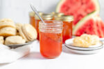 jar or watermelon jelly with biscuits and watermelon in the background