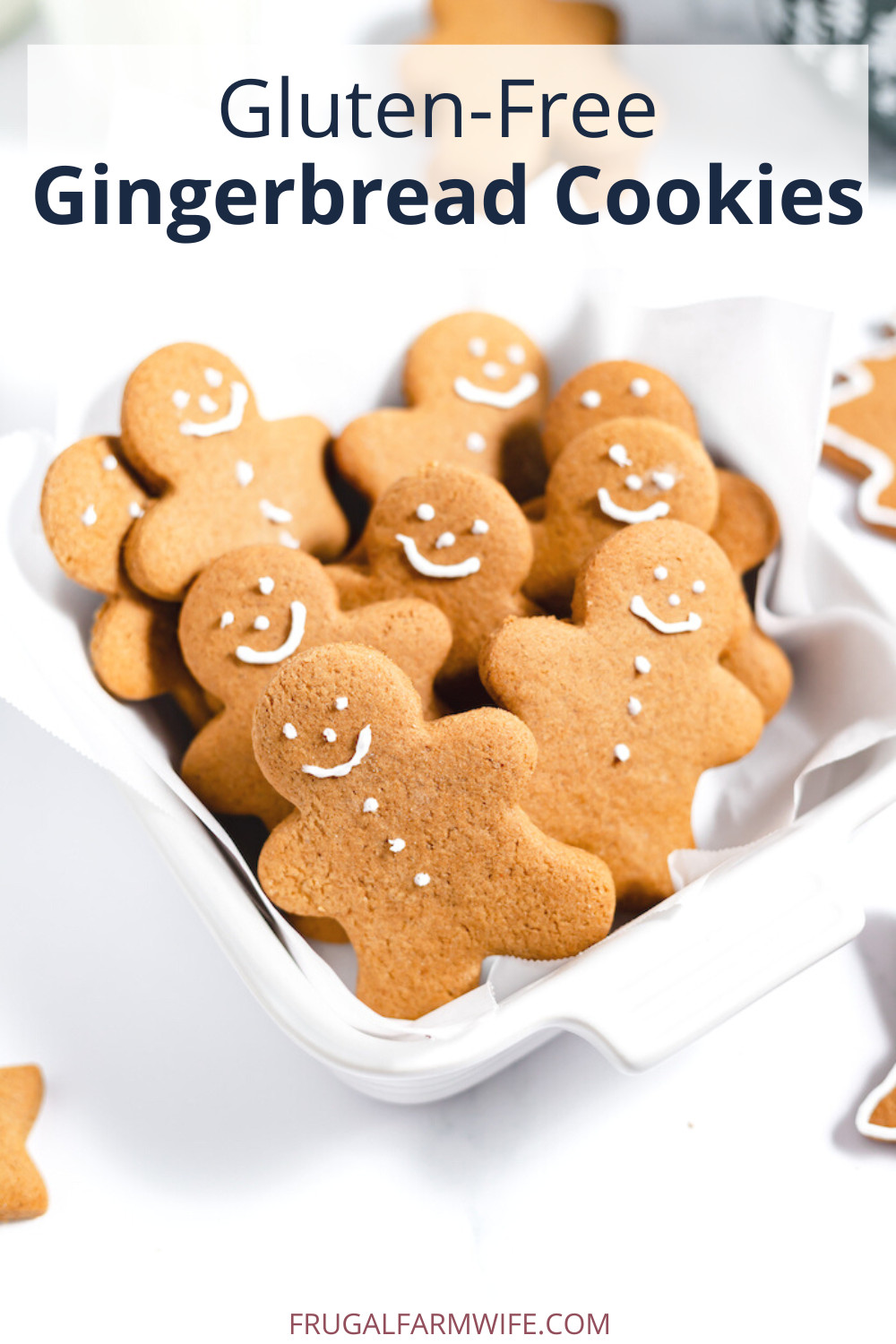 Image shows about ten gluten-free gingerbread person cookies in a dish lined with parchment paper. Text above reads "Gluten-free Gingerbread Cookies"