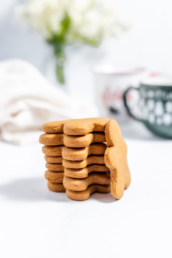 Image shows a neat stack of gingerbread cookies on a table with one cookie leaning against the stack