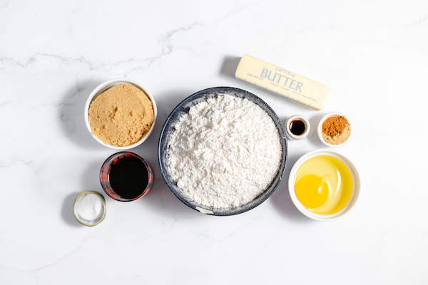 Image, taken from above, shows bowls full of the ingredients needed for making gluten free gingerbread cookies