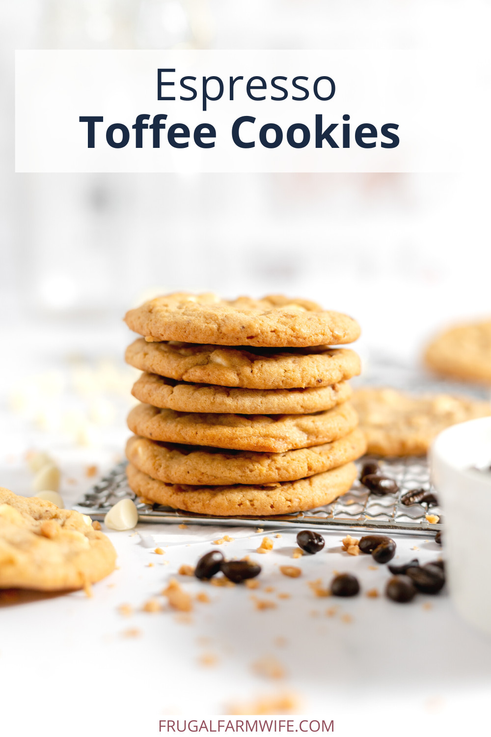 Image shows a stack of espresso toffee cookies stacked on a wire cooling rack. several other cookies, as well as coffee beans and white chocolate chips are scattered nearby on the counter. Text above the stack reads "Espresso Toffee Cookies"