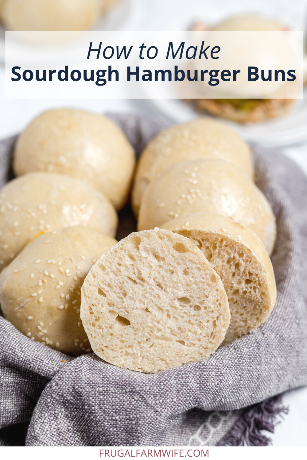 Image shows a napkin lined basket filled with sourdough hamburger rolls with text overlay that reads "how to make sourdough hamburger buns"