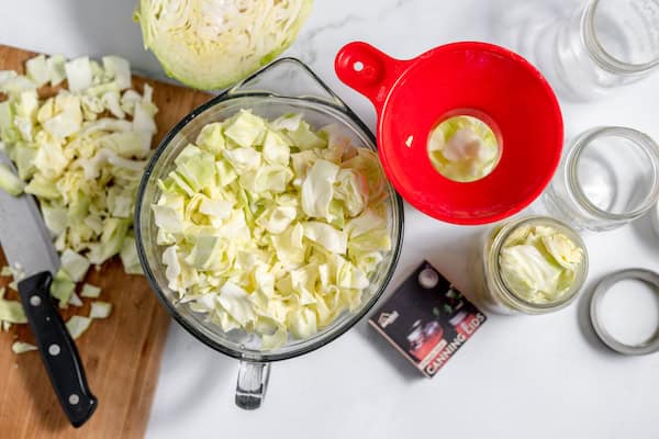 putting chopped cabbage in pint jars