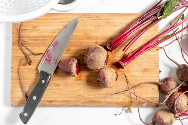 beets on a cutting board, trimming stems