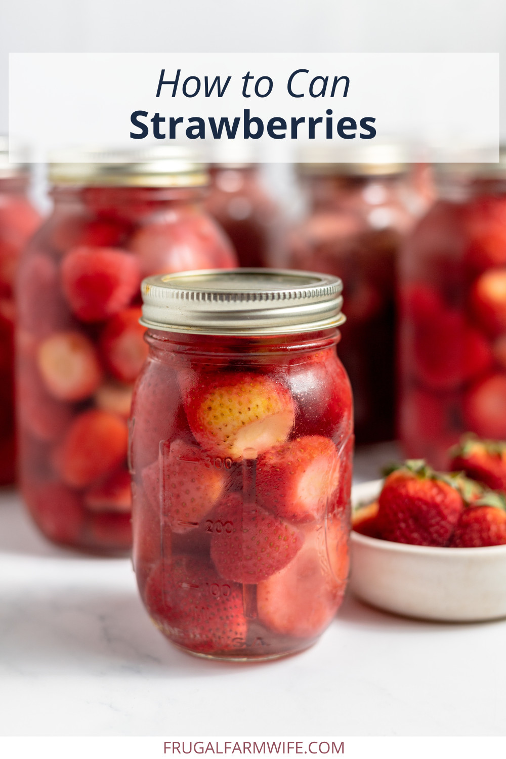 Image shows a jar of canned strawberries, surrounded by fresh strawberries. In the background are more jars of canned berries. Text above reads "How to Can Strawberries"