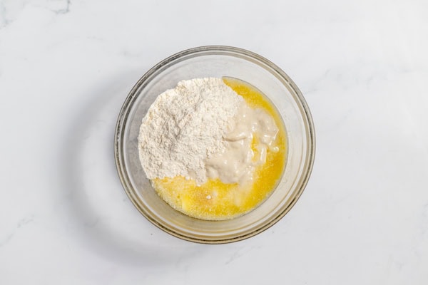 Image, taken from above shows sourdough ingredients in a bowl - flour, starter, salt, and butter.