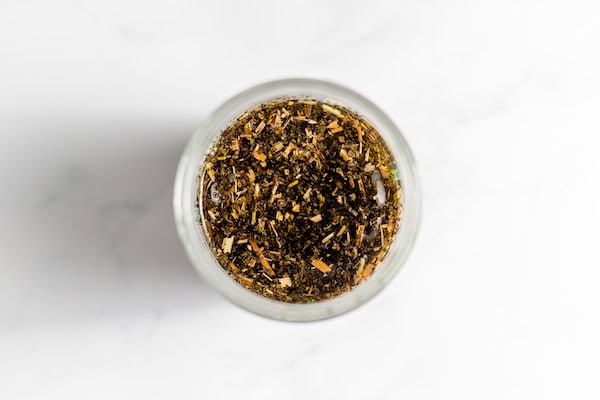 Image, taken from above, shows comfrey leaves in a jar of oil