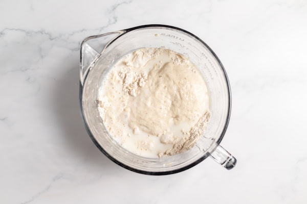 sourdough starter and milk on top of dry ingredients
