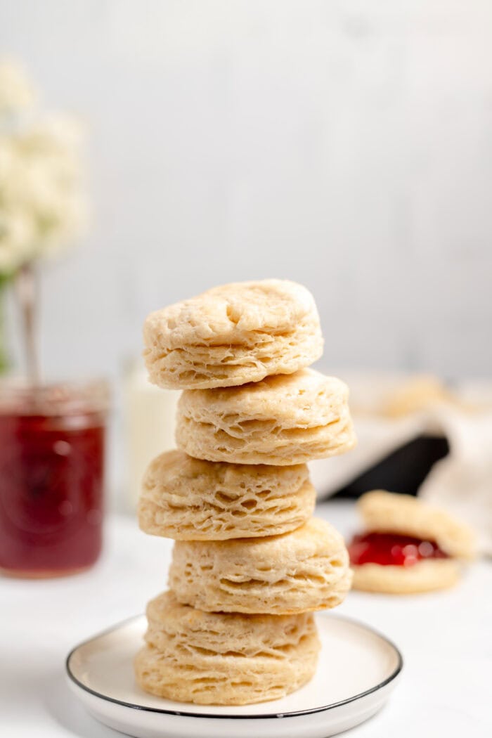 a stack of biscuits with a jar of jam in the background