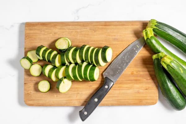 zucchini on a cutting board being sliced