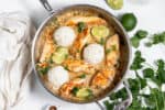 skillet of chicken, rice, and lime wedges