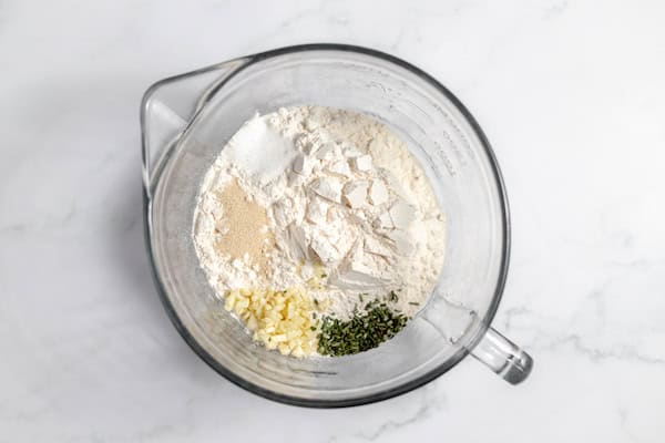 flour, yeast, salt, garlic, rosemary in a bowl
