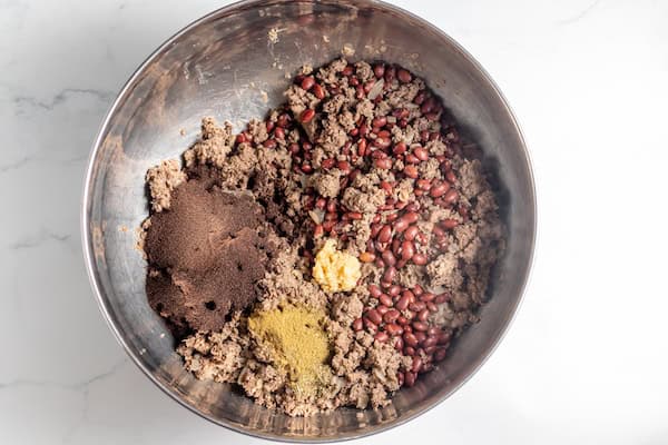 Image, taken from above, shows a bowl with the ingredients for chili being mixed together. 