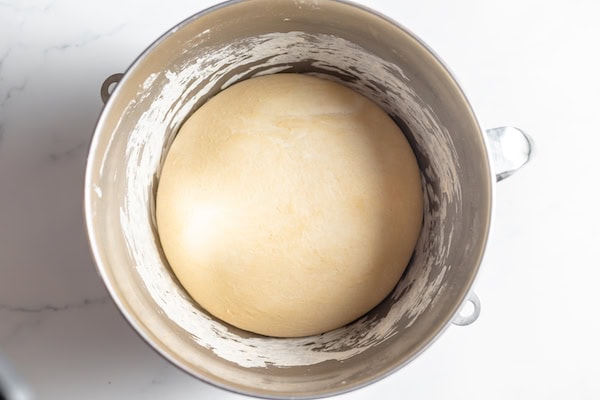 Image, taken from above, shows sourdough risen and ready to make pizza in a large bowl