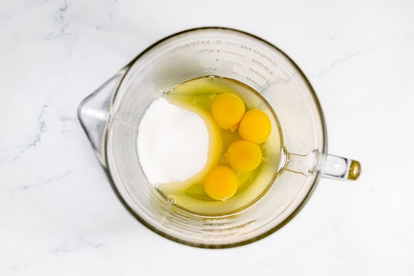 Image, taken from above, shows sugar and eggs for buttermilk lemon pie in a bowl