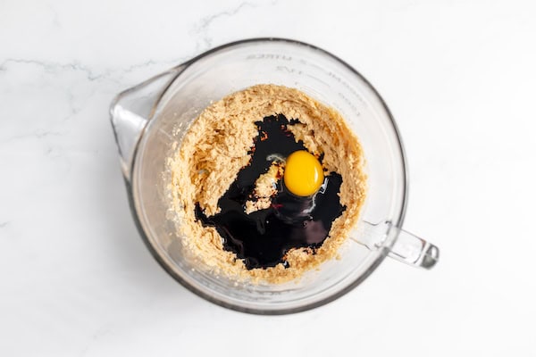 Image, taken from above shows blackstrap and egg being added into butter and sugar mixture