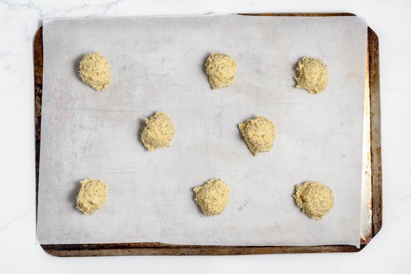 Image, taken from above, shows balls of Earl Grey cookie dough on a baking tray.