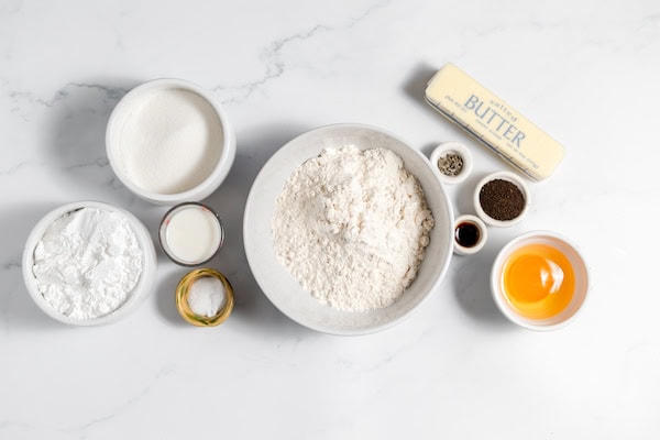 Image, taken from above, shows several bowls full of ingredients for making Earl Grey cookies.
