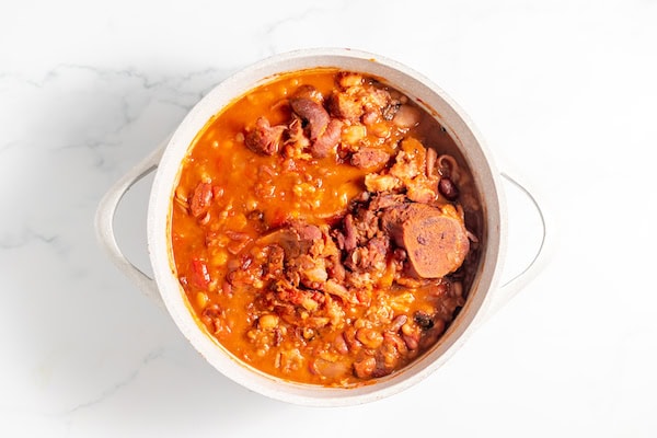 Image, taken from above, shows a pot of 15 bean soup with ham bone still in it.