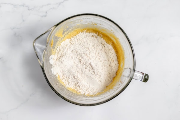 Image, taken from above, shows the dry ingredients added to wet banana mixture.