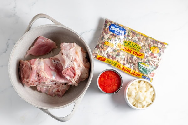 Image, taken from above shows the ingredients for making 15 bean soup with a ham hock placed on a counter. 