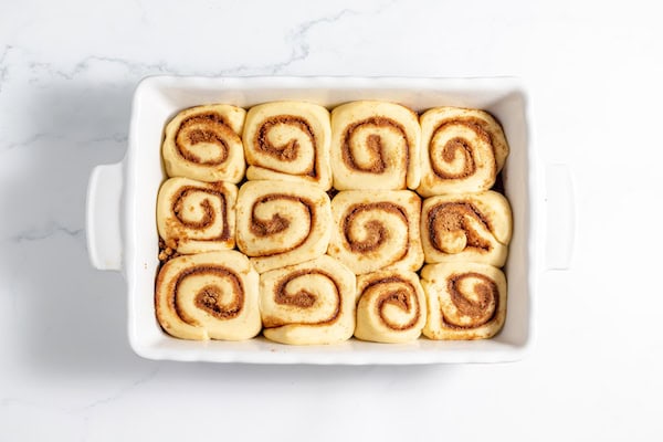 Image, taken from above shows proofed sourdough cinnamon rolls ready to bake
