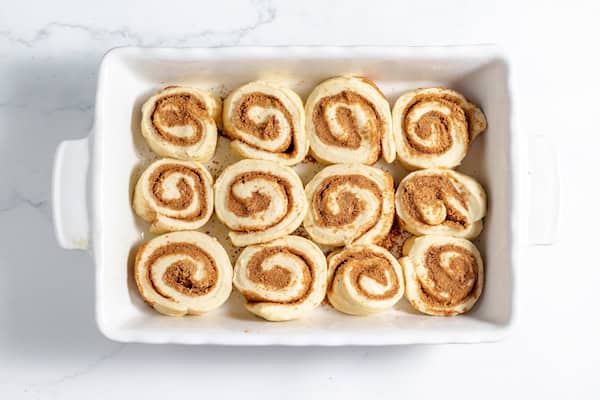 Image, taken from above, shows sourdough cinnamon rolls in pan, not yet risen.