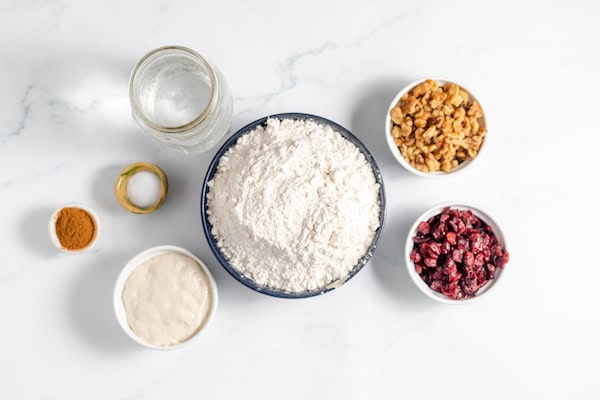 ingredients for making sourdough cranberry walnut bread on a table