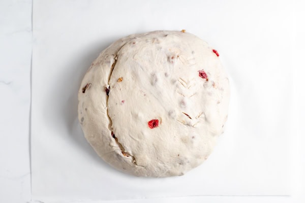 scoring loaf of sourdough cranberry walnut bread before baking