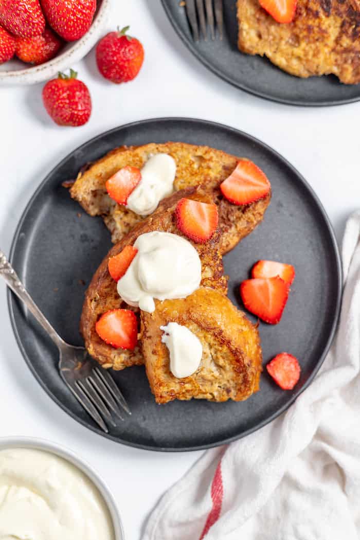 French toast on plate with strawberries and whipped cream