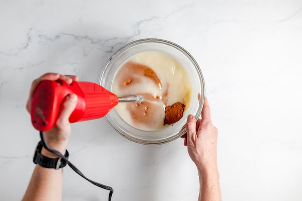 stirring turmeric and essential oils into soap mixture