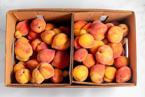 half bushel of peaches in a box