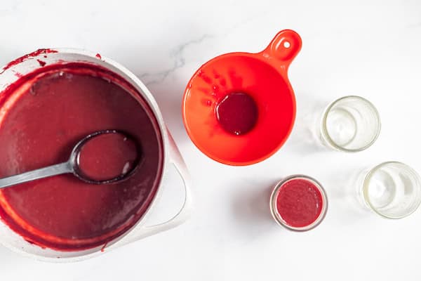 ladling plum sauce into jars