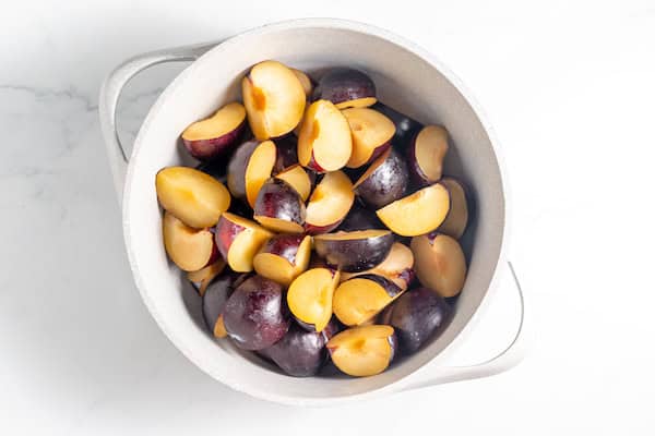 quartered plums in a pan
