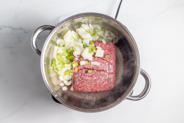 ground beef and vegetables browning in skillet
