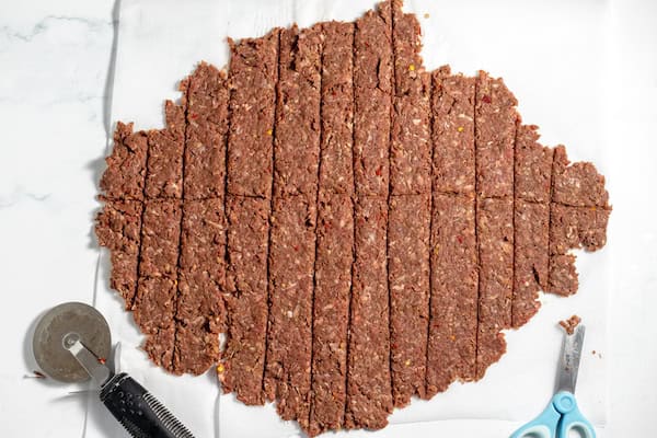 sheet of bison jerky being cut