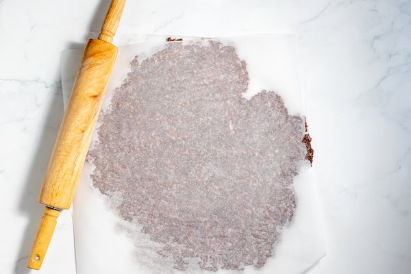 elk meat rolled between sheets of parchment paper