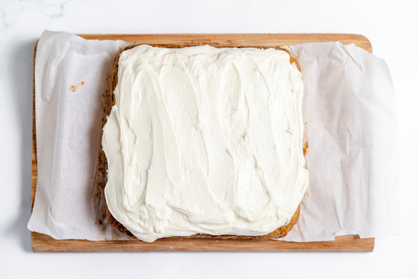 cream cheese icing spread over zucchini cake