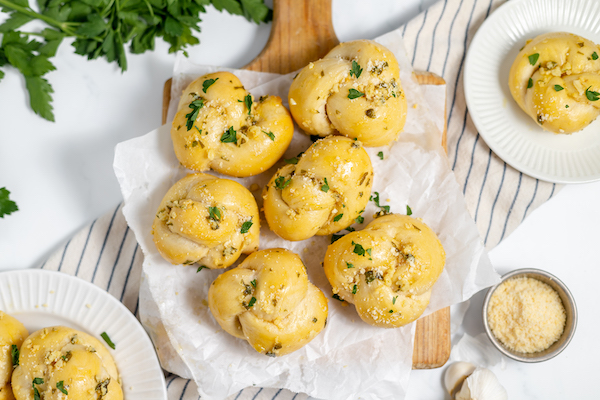 sourdough garlic knots on a cutting board with garlic butter