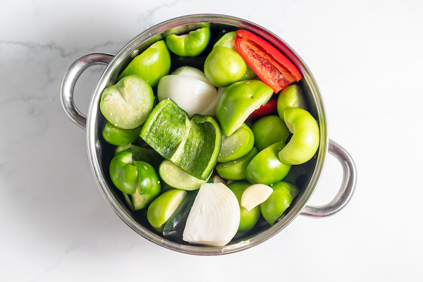 peppers, tomatillos, and jalapeños in a pot