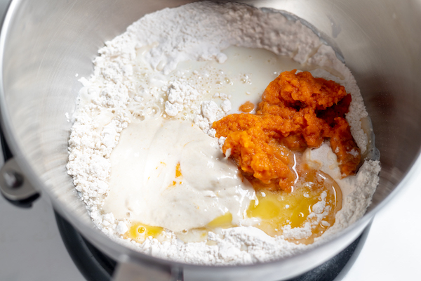 pumpkin, flour, milk, and butter in bowl with sourdough starter