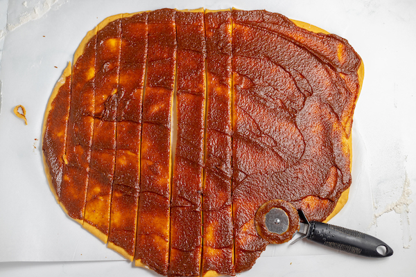 pumpkin filing spread over cinnamon roll dough